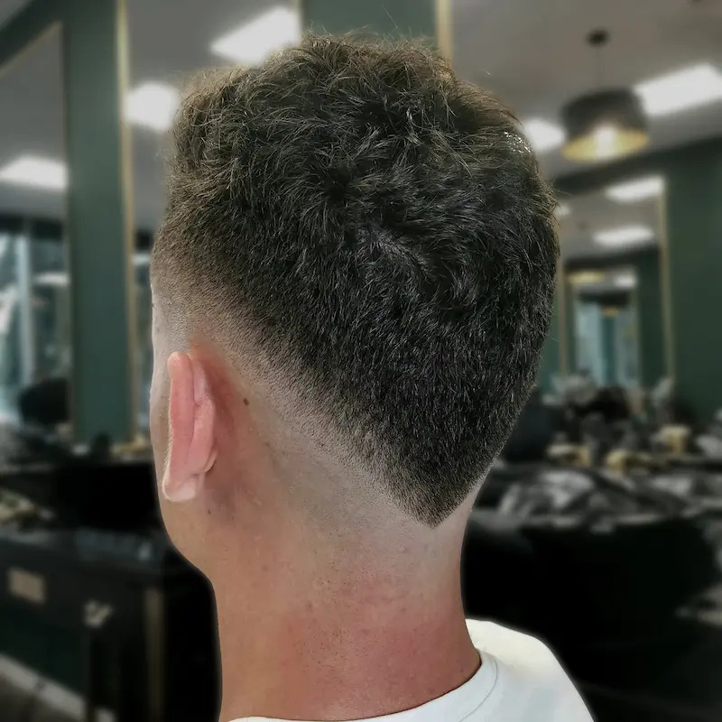 Fryzura burst fade w połączeniu z irokezem (mohawk) od barbera