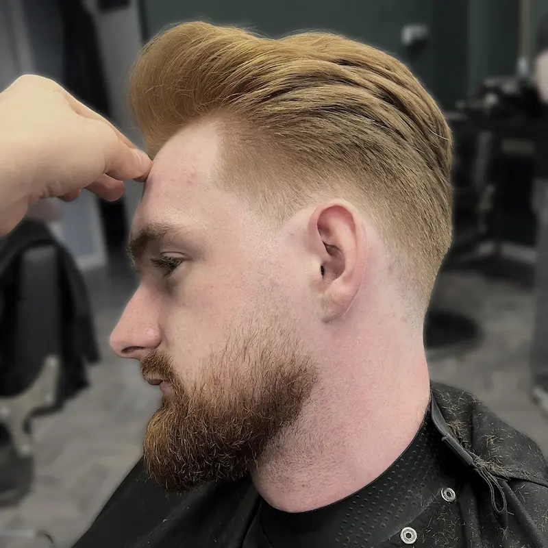 Połączenie fryzury man bun z wygolonymi bokami typu undercut