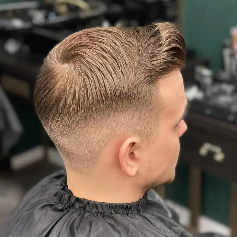 Klasyczna fryzura typu slick back, gładko zaczesana do tyłu